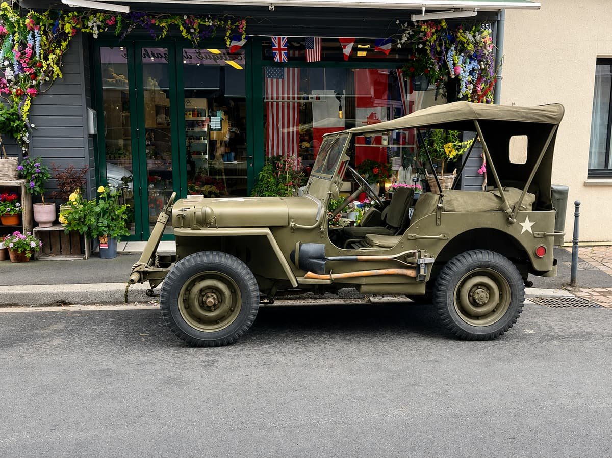 An original army jeep parked in front of a shopfront