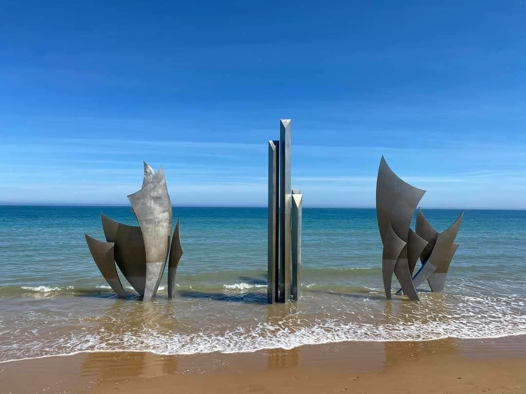Het stalen monument Les Braves in de branding van Omaha Beach