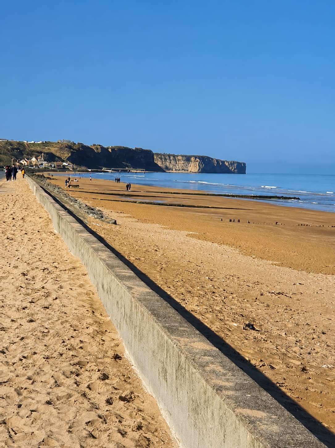 Het brede strand van Omaha Beach onder de klifrand bij eb